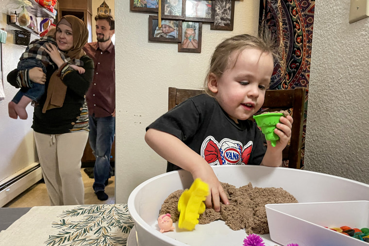 Jibreel Kassir plays with sensory toys, behind his mother Desiree Wines, father Yasser Kassir and baby brother Laith Kassir at home in Englewood, Colo.