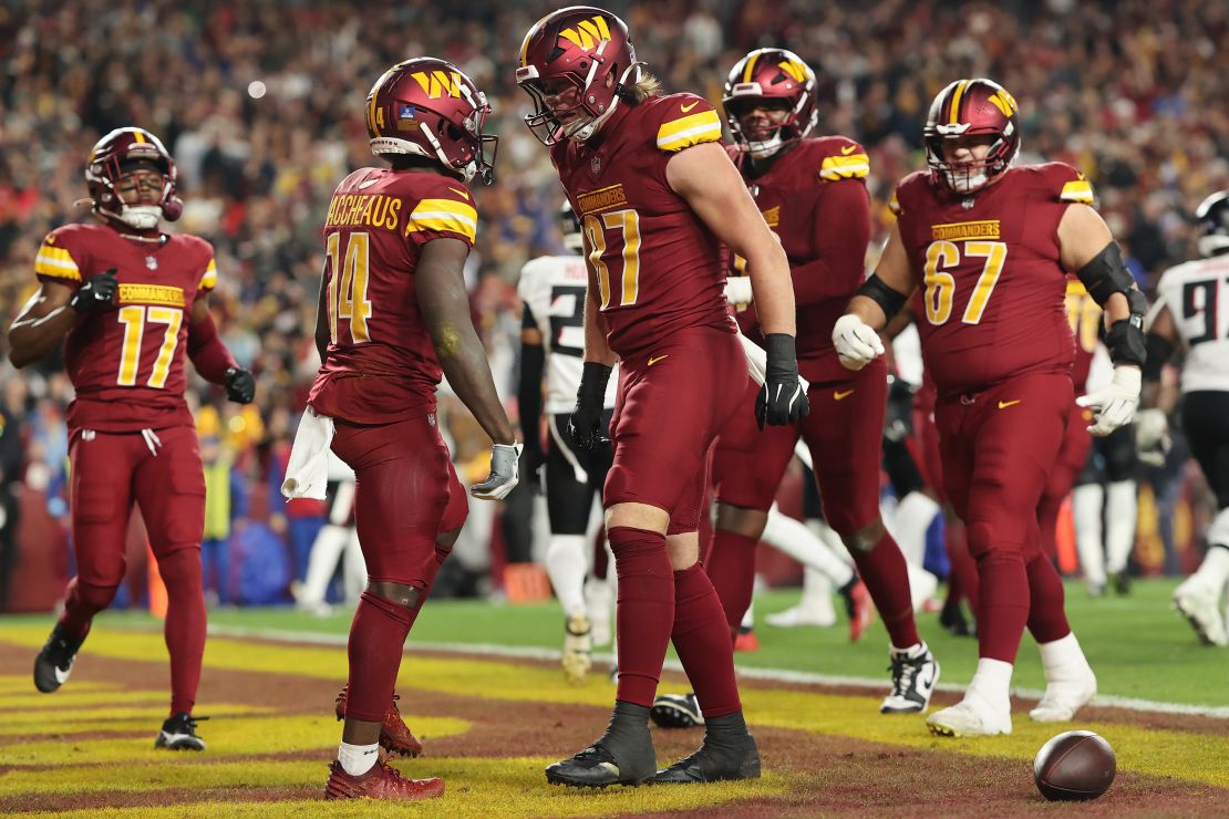 LANDOVER, MARYLAND - DECEMBER 29: Olamide Zaccheaus #14 and John Bates #87 of the Washington Chiefs celebrate after Zaccheaus' first quarter touchdown against the Atlanta Falcons at Northwest Stadium on December 29, 2024 in Landover, Maryland . (Photo by Timothy Nwachukwu/Getty Images)