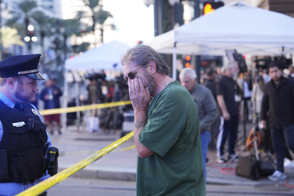 Edward Bruski, center, is emotional at the scene where a car crashed into a crowd in New Orleans' Canal and Bourbon Street, Wednesday, Jan. 1, 2025. (AP Photo/Gerald Herbert)