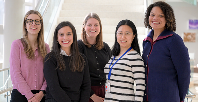 Melissa Goulding, Elise Stevens, Grace Ryan, Chan Zhou, and Sarah Forrester stand together in front of the stairs